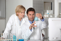 Laboratory team examining blue liquid